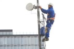 Telekom-Techniker bei der Installation einer Richtfunk-Schssel fr LTE