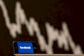 Handy mit Facebook-Logo vor Aktienkurs