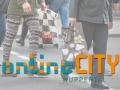 Logo Online City Wuppertal, im Hintergrund Passanten