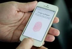 Ein Daumen liegt auf dem Fingerabdruckscanner eines iPhones 5s.