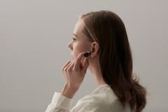 Eine Frau hat das Headset Sony Xperia Ear im Ohr.