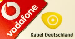 Eine Vodafone-Simkarte liegt auf einer Smartcard von Kabel Deutschland.