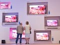  Messebesucher stehen whrend der Elektronikmesse IFA vor Flachbildschirmen auf dem Stand von Philips.