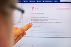 Ein Mann zeigt auf einen Monitor, auf dem eine geflschte E-Mail der Telekom Deutschland GmbH angezeigt wird, bei der sich beim ffnen eines Links ein Virus auf dem Computer installiert.