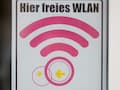 Ein Schild "Hier freies WLAN" weist auf einen Hotspot hin.