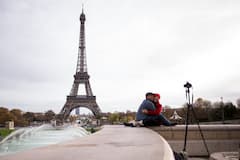 Ein junges Paar macht vor dem Eifelturm in Paris (Frankreich) ein Selbstportrt.