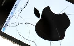 Das Logo von Apple ist auf einem Apple iPhone 4 mit gesplittertem Display zu sehen. 