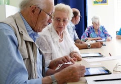 Senioren lernen bei einem Kurs die Verwendung eines Tablets