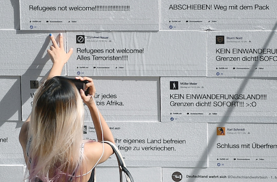 Hasskommentare aus dem Internet visualisiert auf einer Styropor-Mauer
