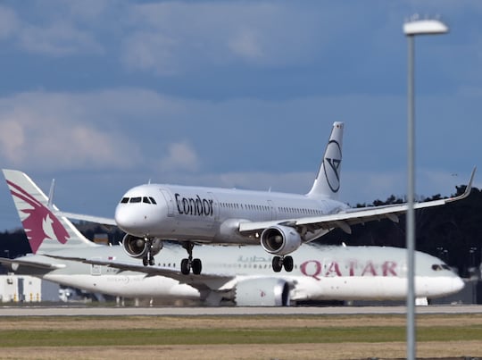 Airbus A321 (Condor) landet, whrend Boeing 787 (Qatar) auf Startfreigabe wartet.