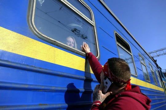 Szene aus der Ukraine: Eine Frau reist mit dem Zug aus, der Mann muss sein Land weiter verteidigen. Kontakte per Smartphone bleiben wichtig.